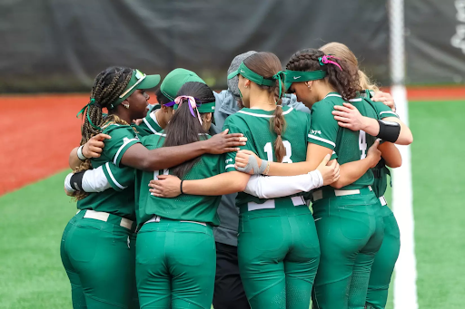 Pride Game - softball team of dartmouth in a huddle